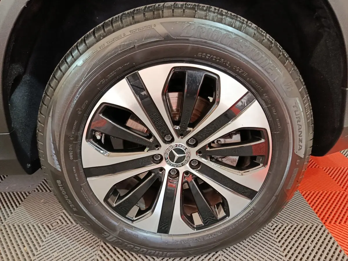 Gros plan sur la roue avant droite du Mercedes GLC 300 e Business Line noir avec jante alliage bicolore.