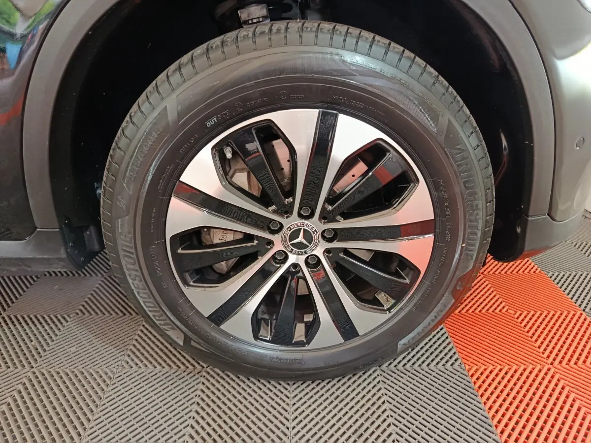 Gros plan sur la roue avant droite du Mercedes GLC 300 e Business Line noir avec jante alliage bicolore.