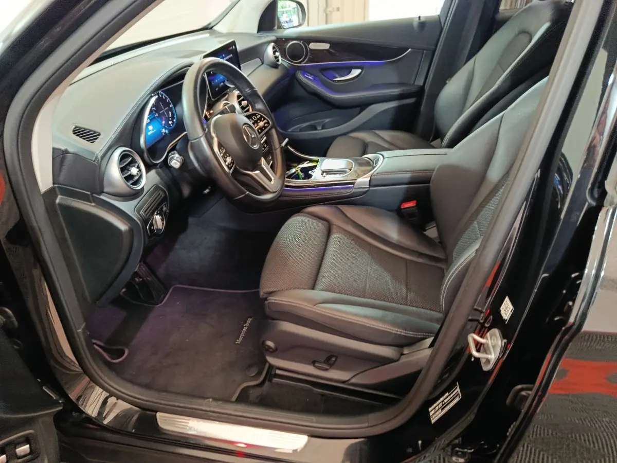 Intérieur côté conducteur d'une Mercedes GLC 300 e Business Line noire, avec tableau de bord numérique et sellerie cuir noire.