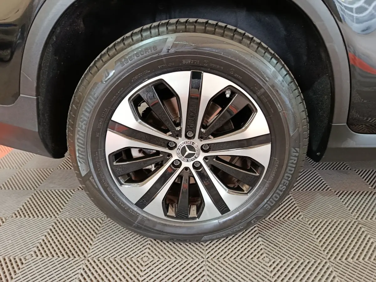 Gros plan sur la roue avant droite du Mercedes GLC 300 e Business Line noir avec jante alliage bicolore.