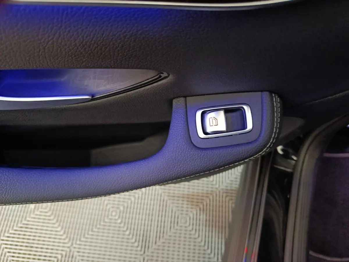 Gros plan sur la poignée intérieure cuir noir et bouton de verrouillage de porte côté gauche d'une Mercedes GLC 300 e Business Line 2020.