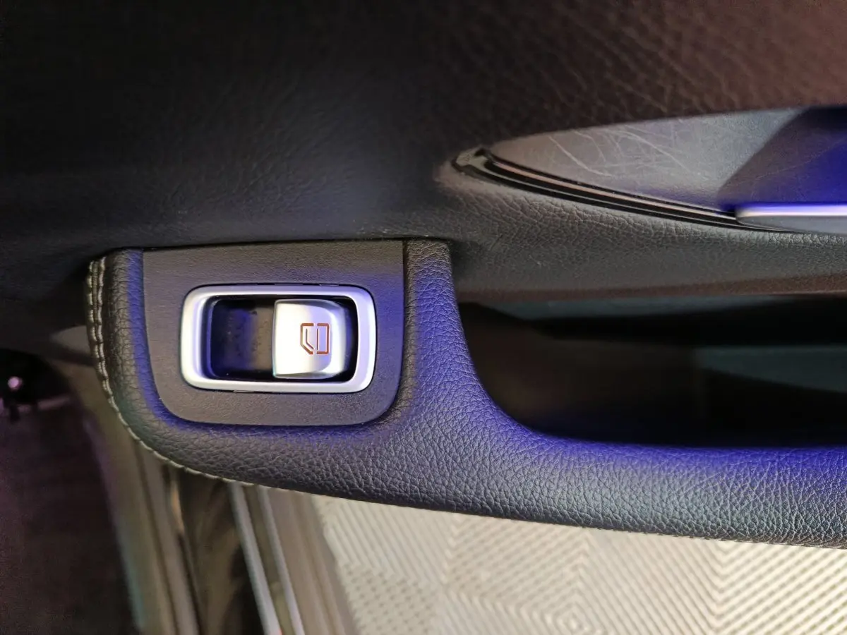 Gros plan sur le bouton de commande de vitre électrique intégré dans la porte intérieure noire du Mercedes GLC 300 e.