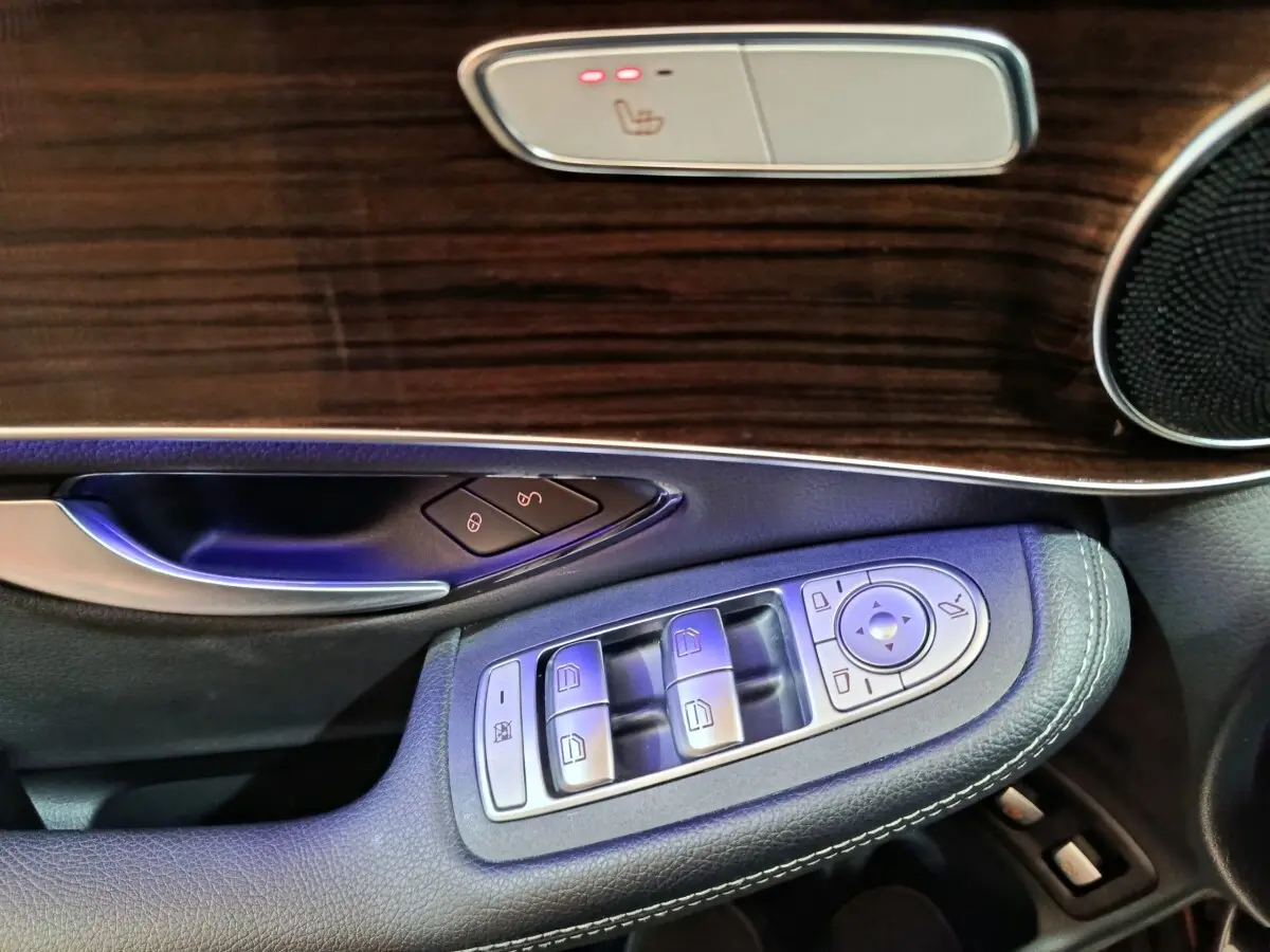 Détail de la porte côté conducteur du Mercedes GLC 300 e Business Line 2020 avec commandes alu et garniture bois foncé.