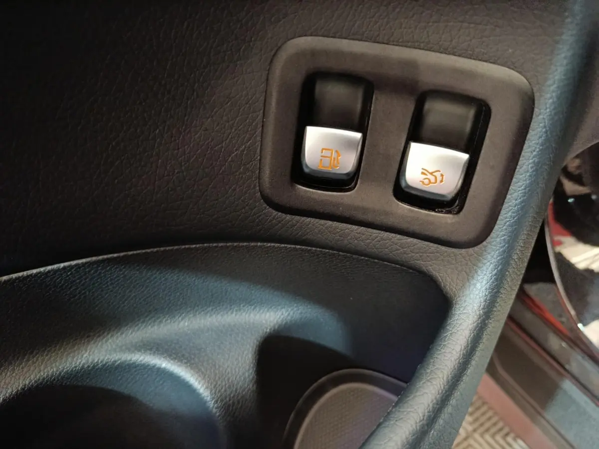 Gros plan sur les boutons d'ouverture du réservoir et du coffre dans l'habitacle noir du Mercedes GLC 300 e Business Line.
