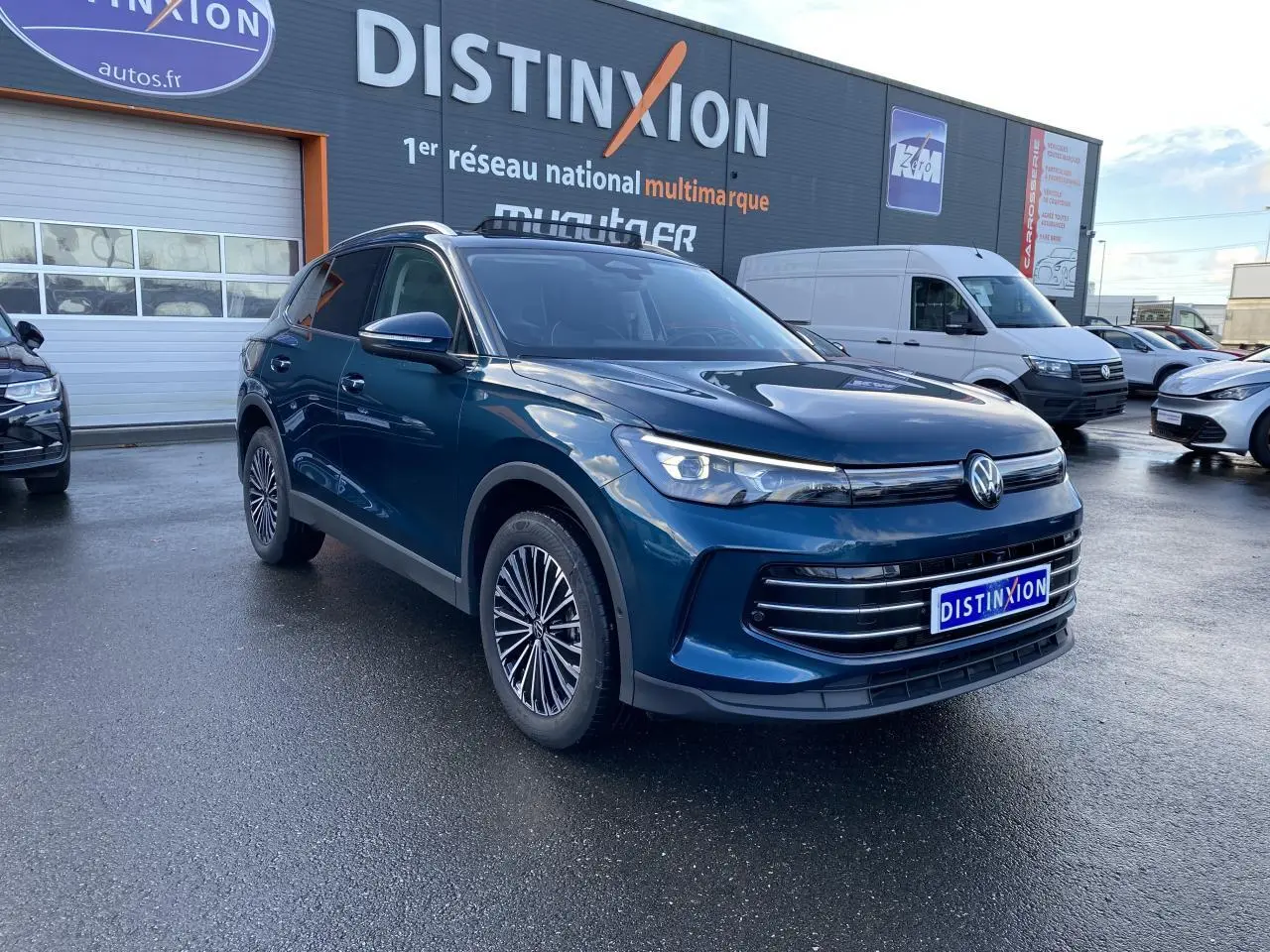 Volkswagen Tiguan 1.5 eHybrid bleu Nightshade en 3/4 avant droit avec phares LED et jantes stylisées.