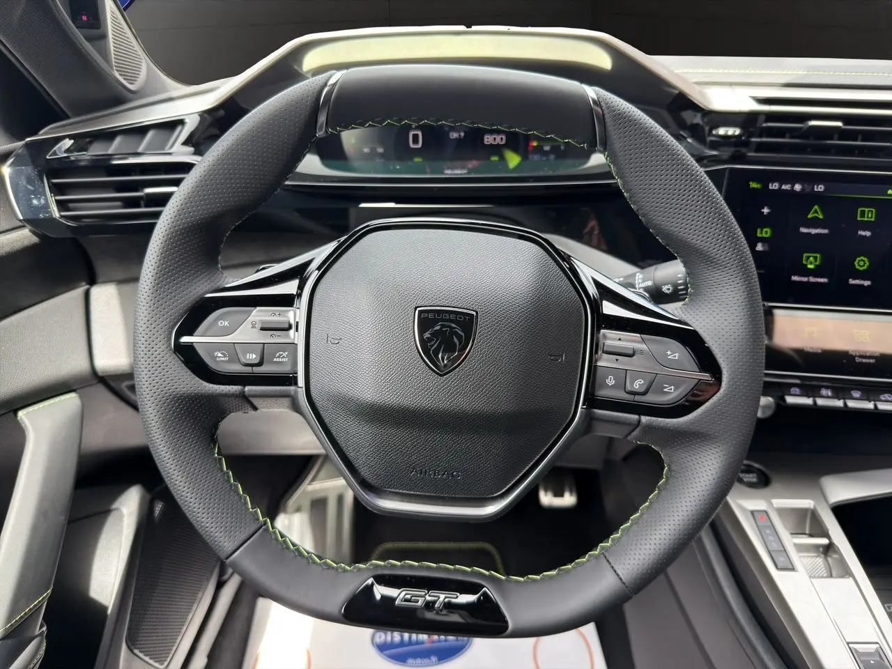 Volant GT en cuir noir avec surpiqûres vert Adamite, tableau de bord numérique 10'' et console centrale moderne de la Peugeot 308 2026.