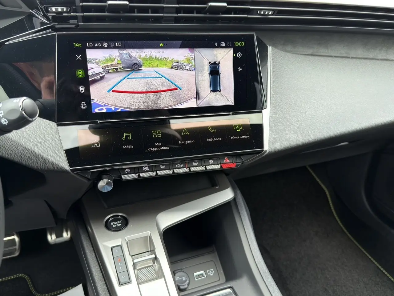 Vue intérieure de la console centrale de la Peugeot 308 GT 2026, écran tactile avec caméra 360° et commandes modernes.