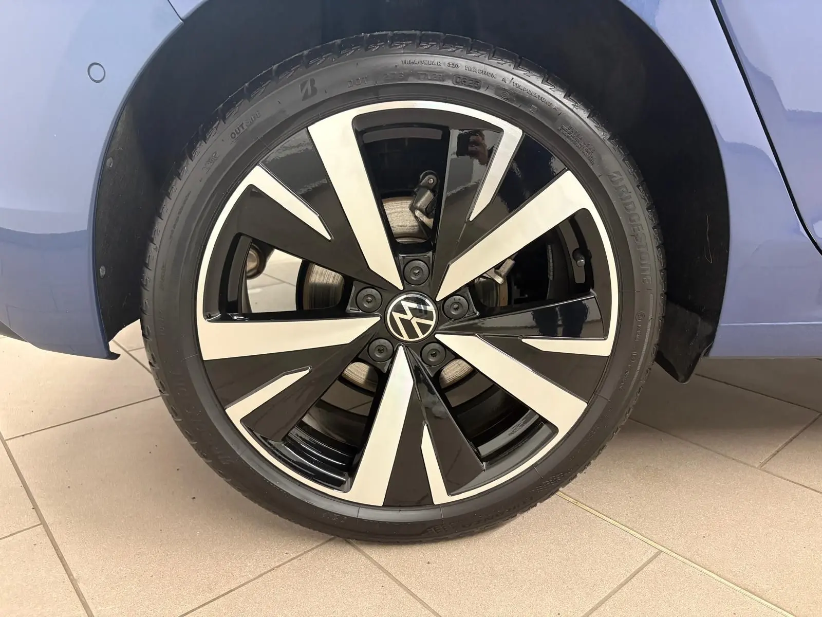 Gros plan sur la jante alliage 18'' Catania noire et argentée de la Volkswagen Golf Bleu Anémone, côté arrière droit.