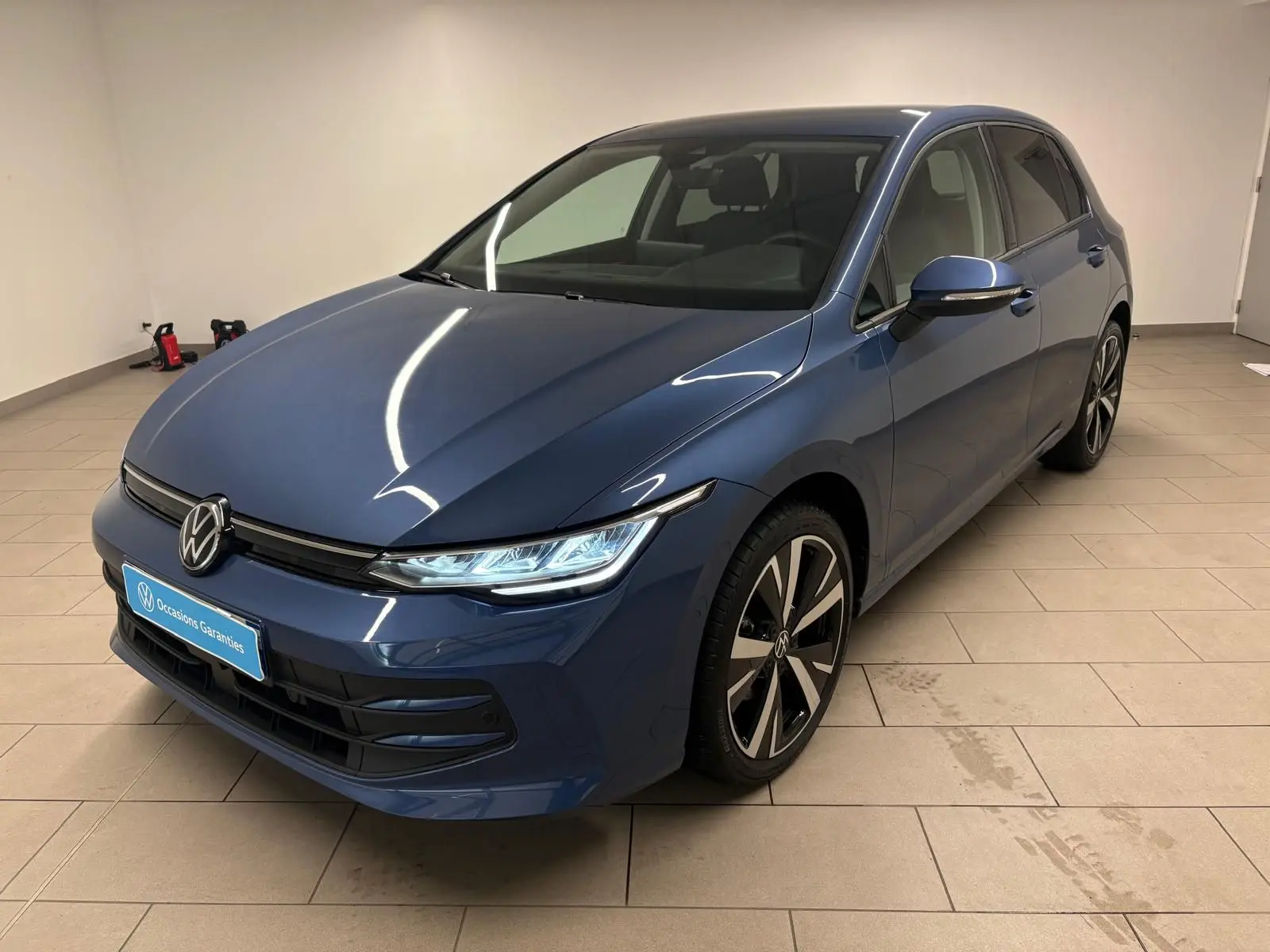 Vue 3/4 avant droite de la Volkswagen Golf 1.5 eTSI 116 DSG7 en bleu Anémone avec jantes alliage 18'' Catania.