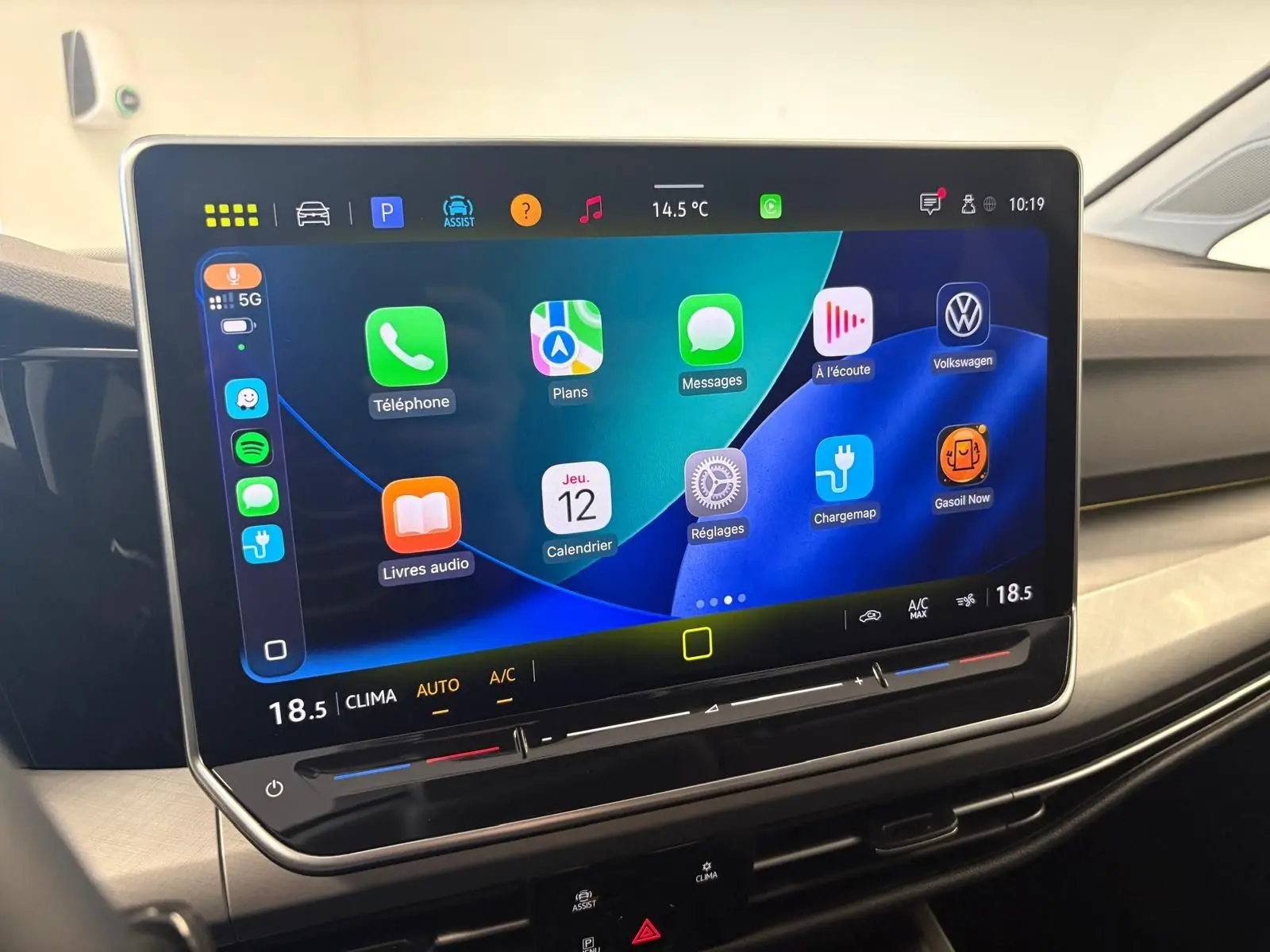 Écran tactile central de la Volkswagen Golf 2025 affichant les applications connectées et la climatisation à 18,5°C.