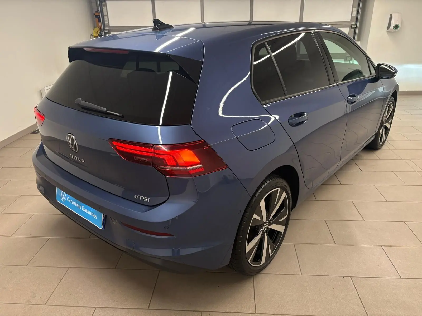 Vue 3/4 arrière droite d'une Volkswagen Golf 1.5 eTSI 116 DSG7 Bleu Anémone avec jantes alliage 18'' Catania.