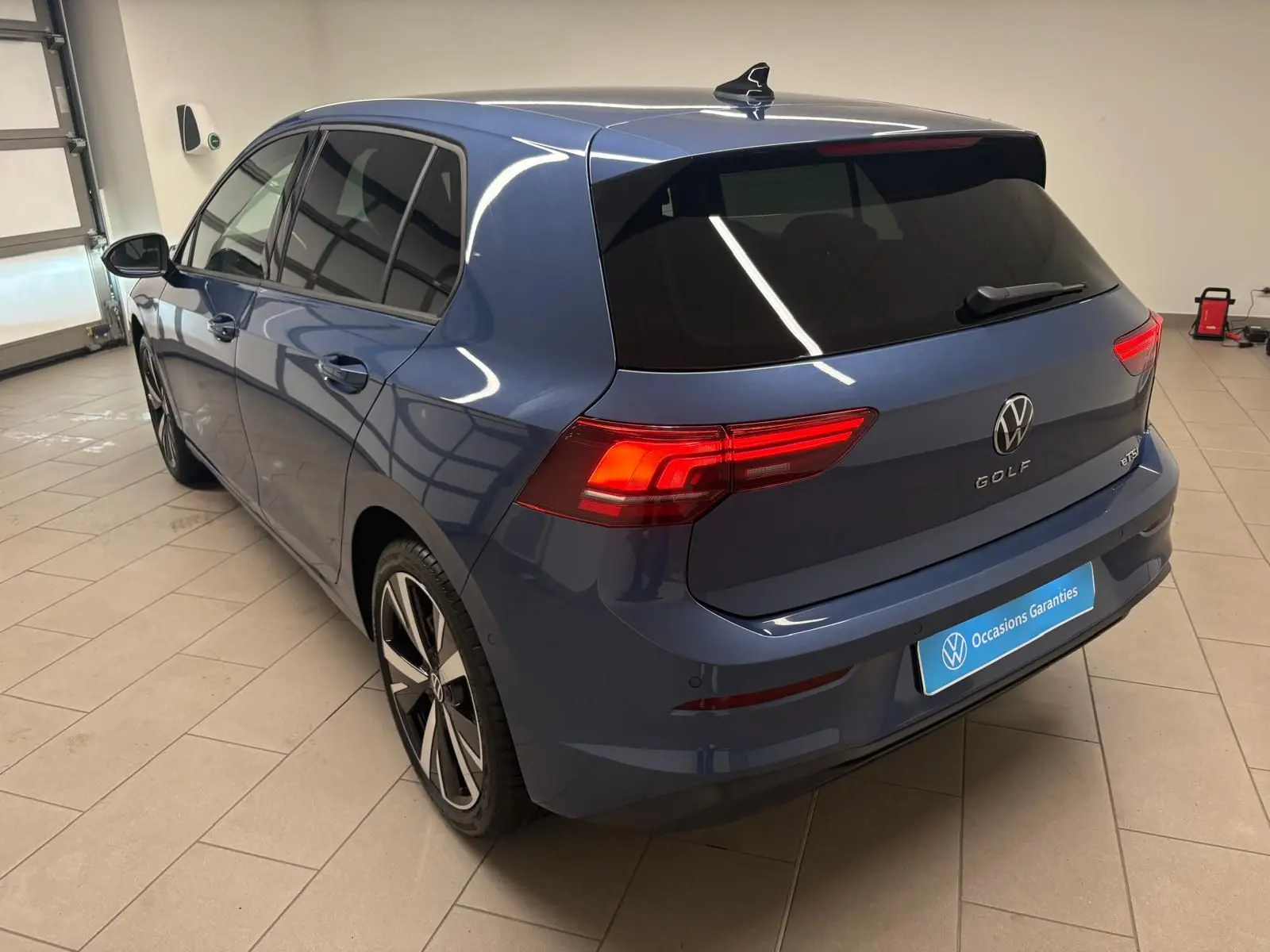 Vue 3/4 arrière droite d'une Volkswagen Golf 1.5 eTSI 116 DSG7 Bleu Anémone avec jantes alliage 18'' Catania.
