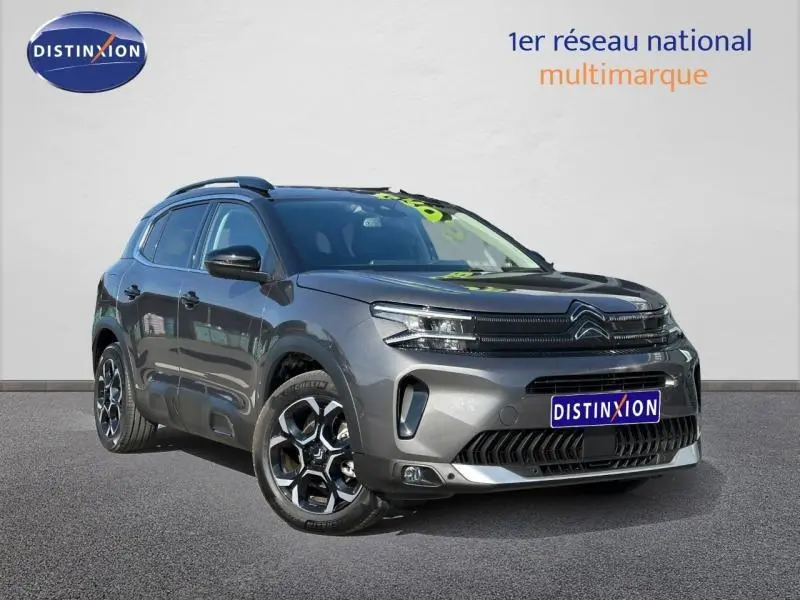 Citroën C5 Aircross gris Platinium vue 3/4 avant droit, SUV hybride avec jantes distinctives et calandre moderne.