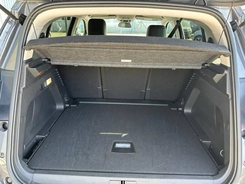 Vue arrière du coffre ouvert d'un Citroën C5 Aircross gris Platinium 2025, montrant l'espace de chargement et la tablette cache-bagages.