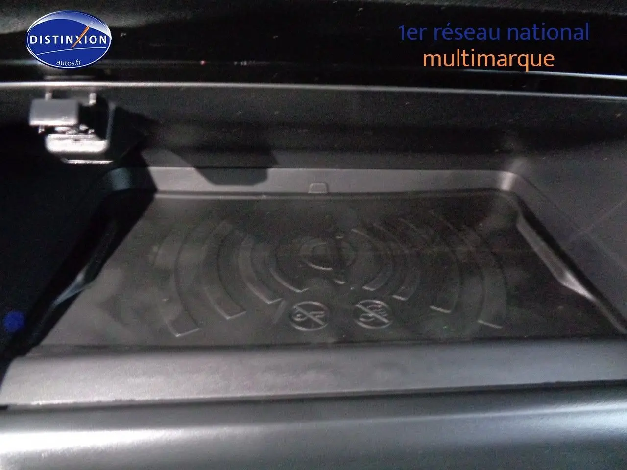 Gros plan sur le compartiment intérieur noir du Peugeot 2008 rouge Elixir Metal, version 2023 essence.