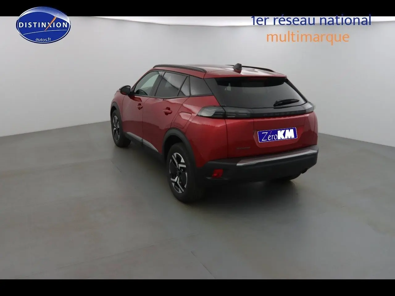 Vue 3/4 arrière droite d'un Peugeot 2008 rouge Elixir Metal dans un studio blanc, avec jantes noires bicolores.