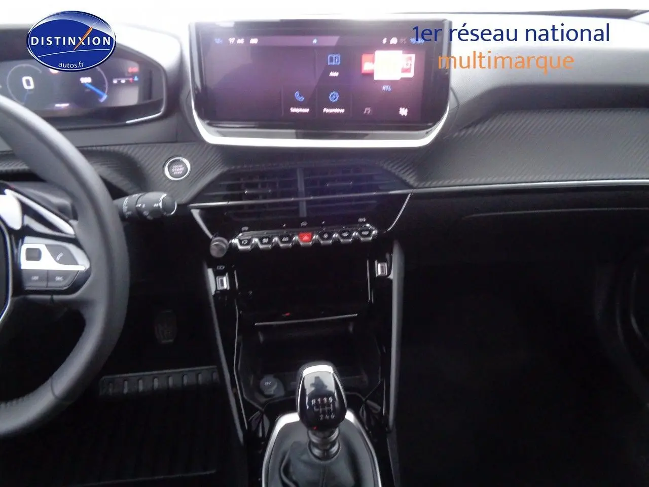 Intérieur Peugeot 2008 rouge Elixir, vue centrée sur la console avec levier de vitesse manuel et écran tactile.