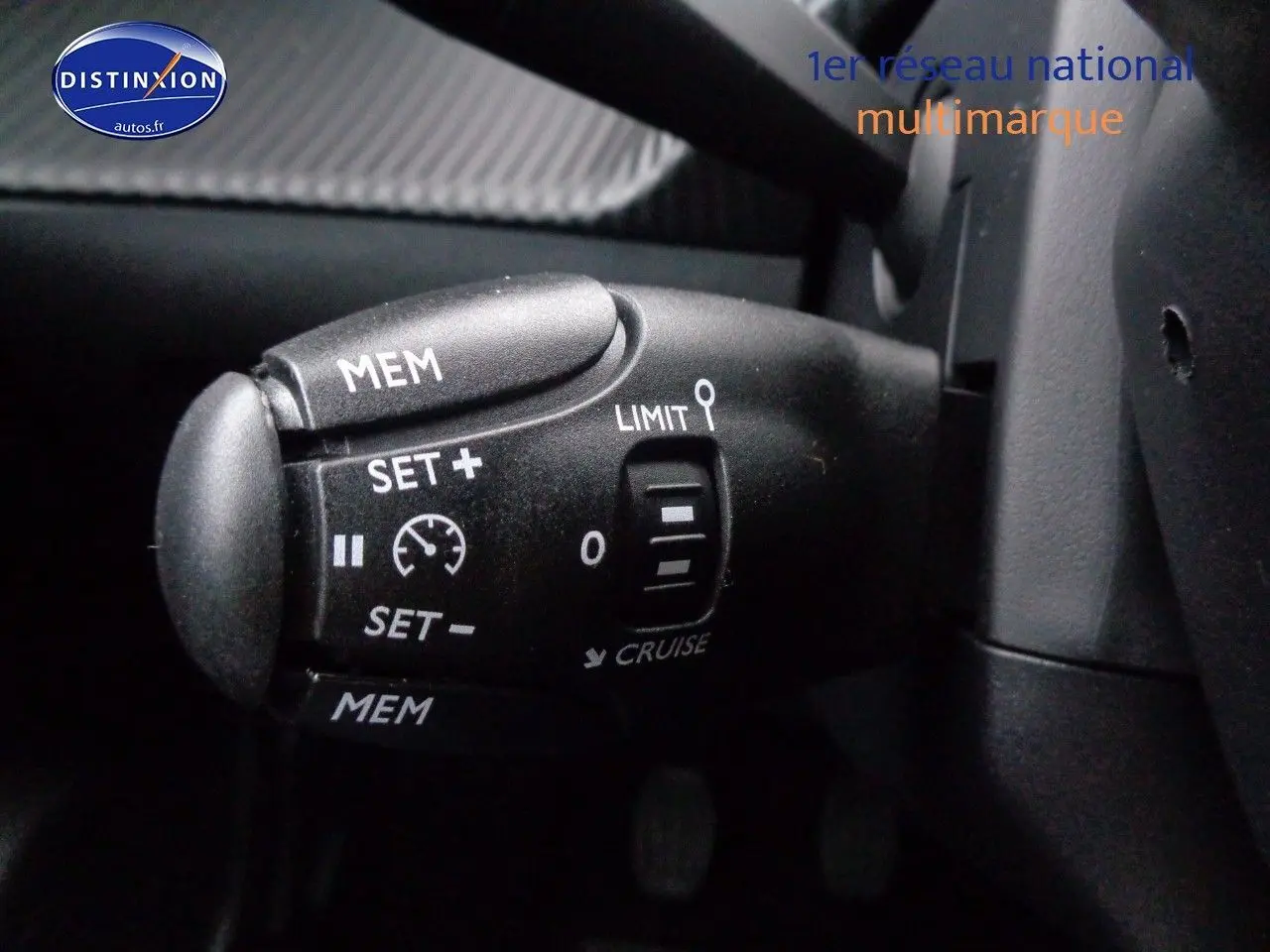 Gros plan sur la commande de régulateur de vitesse du Peugeot 2008 rouge Elixir Metal, version 2023.