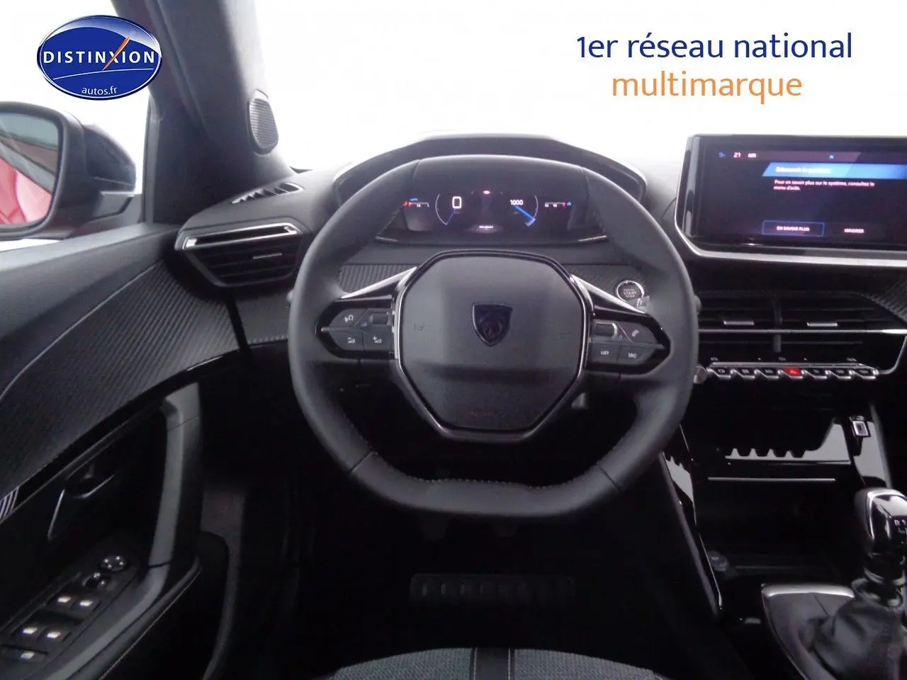 Vue intérieure centrée sur le volant compact et le tableau de bord numérique d'une Peugeot 2008 rouge Elixir Metal.