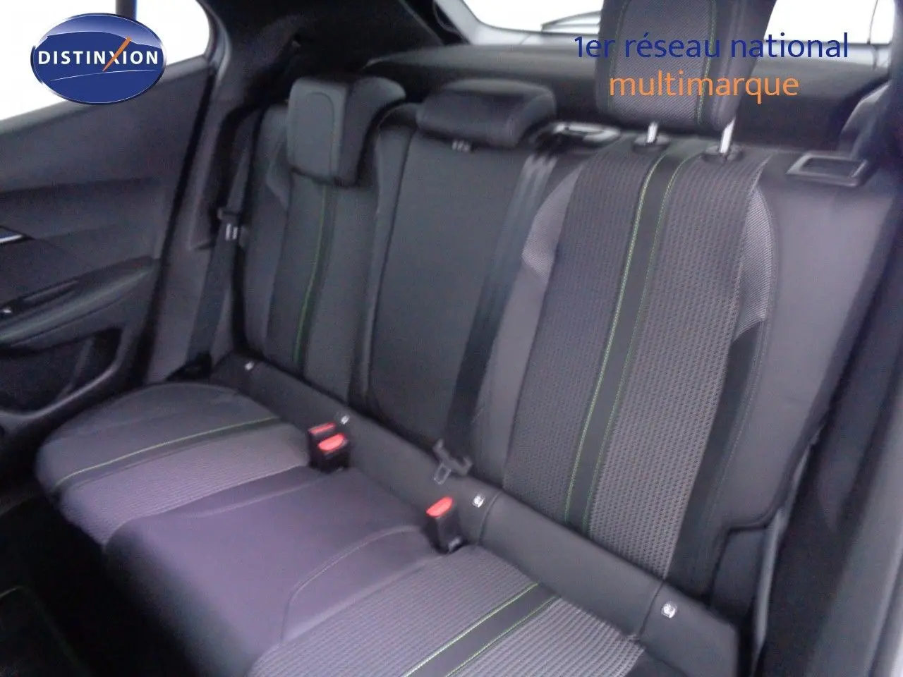 Vue intérieure des sièges arrière en tissu gris avec surpiqûres vertes d'une Peugeot 2008 2023.