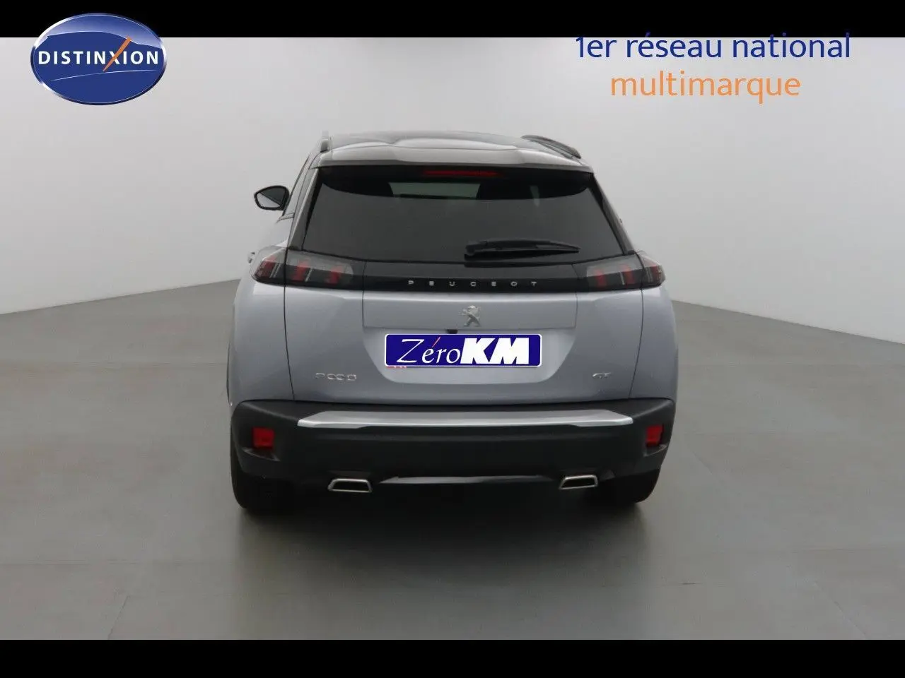 Vue arrière d'un Peugeot 2008 gris Artense métal avec toit noir, double sortie d'échappement et feux LED horizontaux.