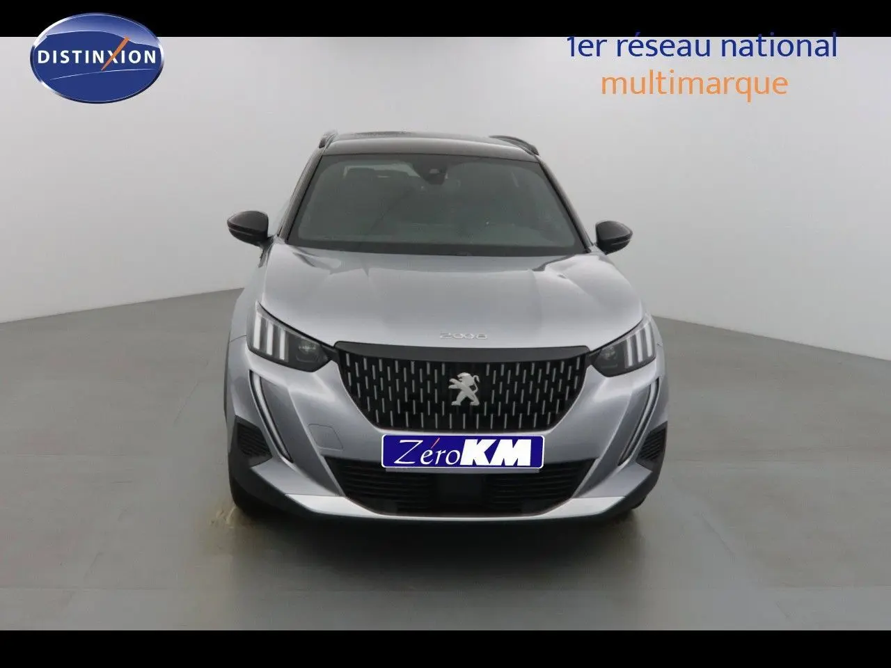 Peugeot 2008 gris Artense métal avec toit noir, vue frontale mettant en valeur la calandre et les phares LED.