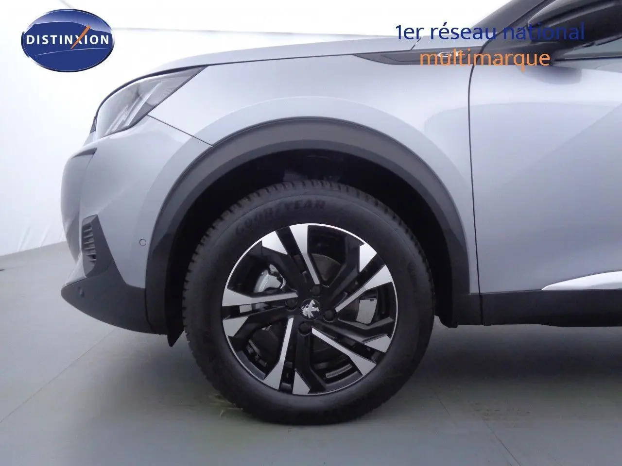 Gros plan sur la roue avant gauche d’un Peugeot 2008 gris Artense métal avec jante noire et argentée.