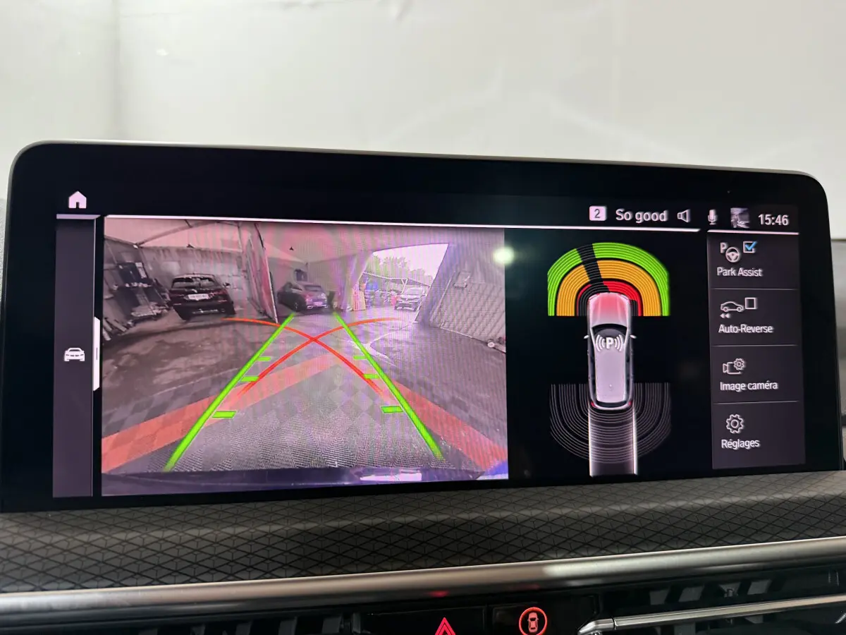 Écran central affichant la caméra de recul et l'assistance au stationnement du BMW X3 bleu hybride rechargeable 2023.