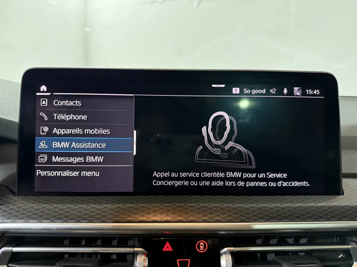 Écran tactile central du BMW X3 xDrive30e 2023 affichant le menu BMW Assistance en intérieur.