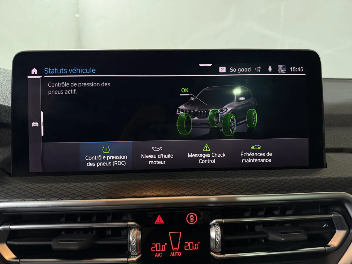 Écran tactile central du BMW X3 bleu 2023 affichant le contrôle actif de pression des pneus et autres statuts véhicule.