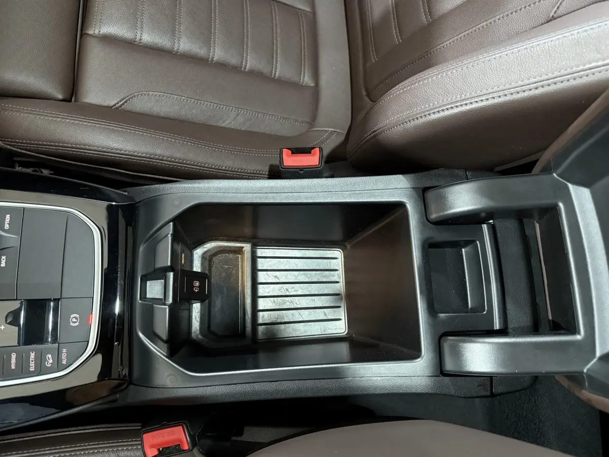 Vue plongeante sur la console centrale noire et les sièges marron du BMW X3 xDrive30e 2023 M Sport hybride rechargeable.