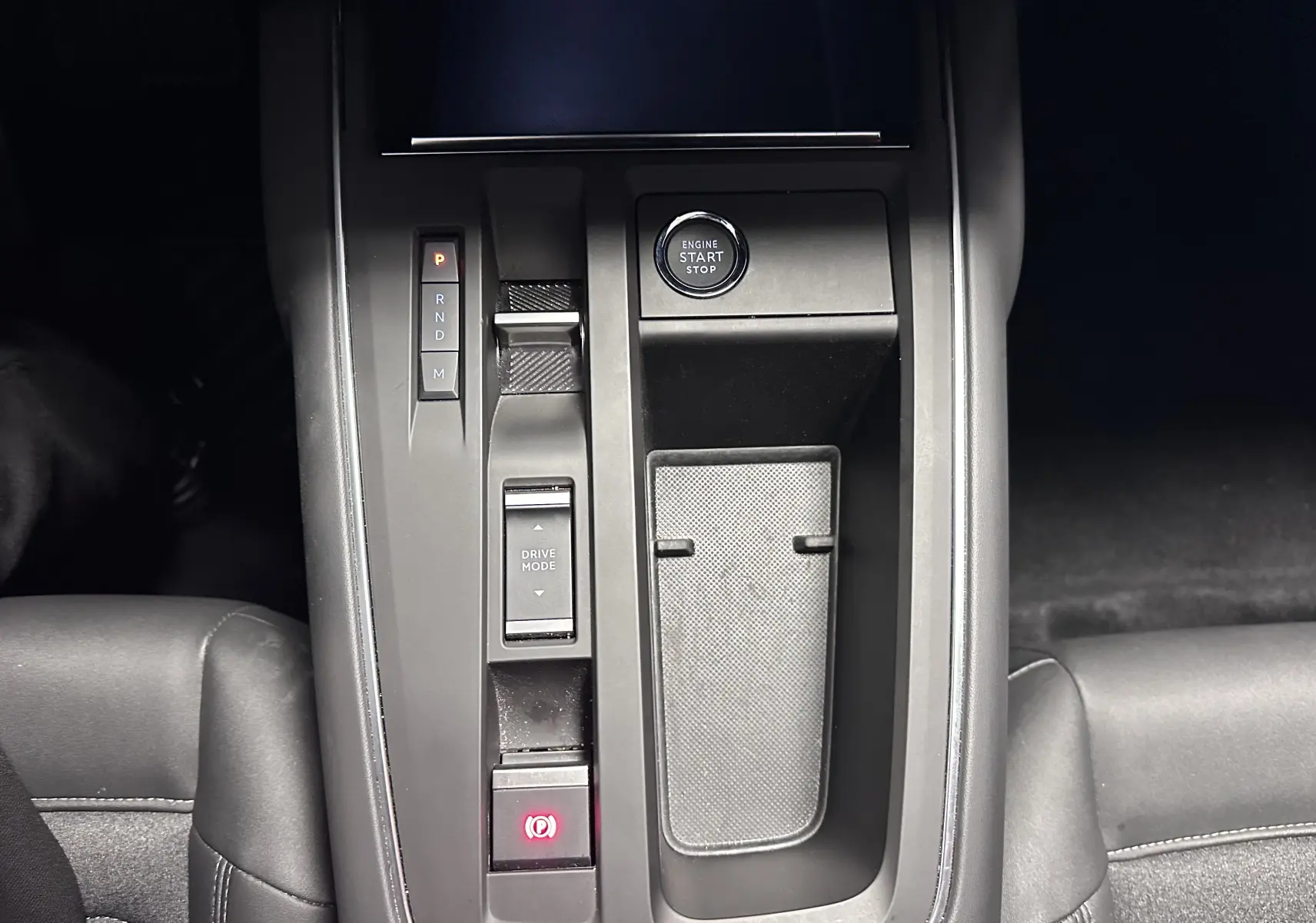 Vue plongeante sur la console centrale noire du Citroën C5 Aircross hybride 2025 avec boutons de démarrage et boîte auto.