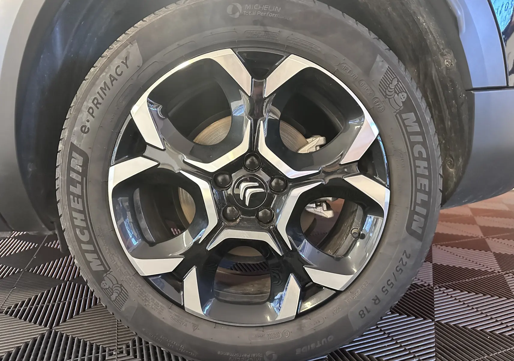 Gros plan sur la jante alliage 18 pouces biton et pneu Michelin du côté avant droit d’un Citroën C5 Aircross noir hybride.