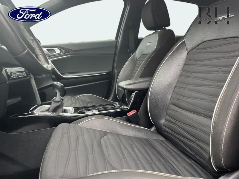 Vue intérieure côté conducteur de la Kia CEE'D 1.0 T-GDI GT Line 2023 avec sièges en cuir synthétique noir et console centrale brillante.