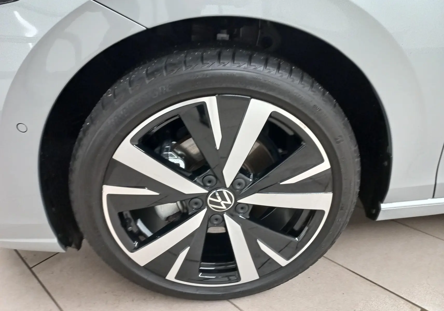 Gros plan sur la jante alliage 18'' Catania noire et argentée de la Volkswagen Golf 2025 Argent Dolomite, côté gauche.