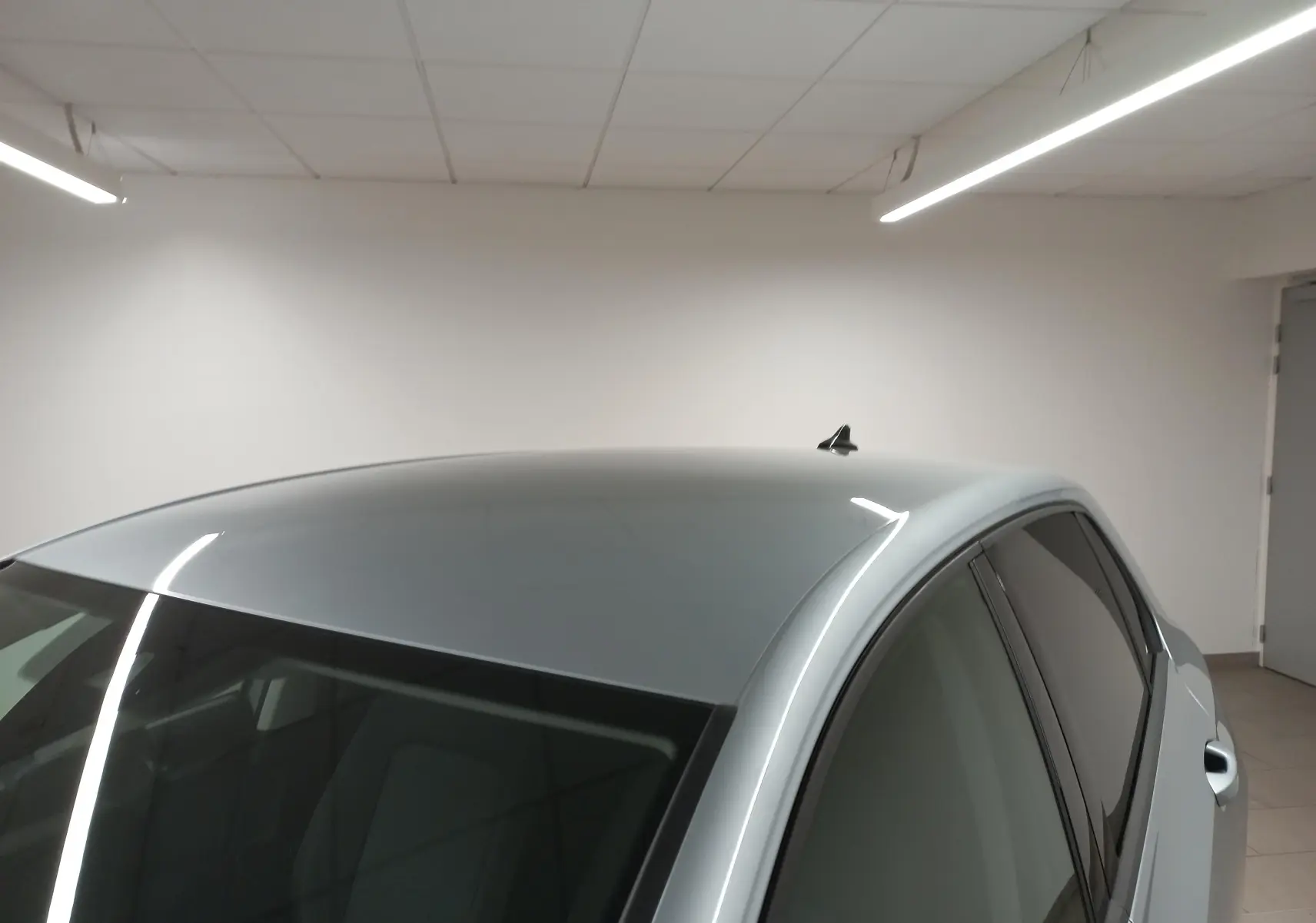 Vue rapprochée du toit et des vitres teintées d'une Volkswagen Golf 2025 argent Dolomite en intérieur.