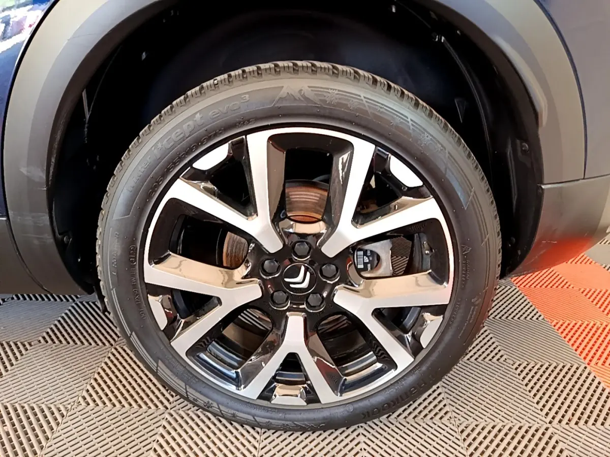 Gros plan sur la roue avant droite du Citroën C5 Aircross 2023 avec jante alliage bicolore noire et argentée.