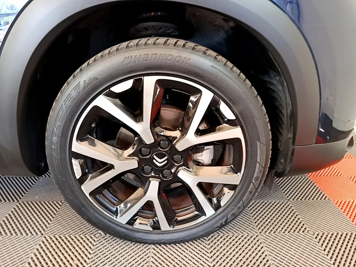 Gros plan sur la roue avant droite noire et argentée du Citroën C5 Aircross 2023, avec logo Citroën visible.