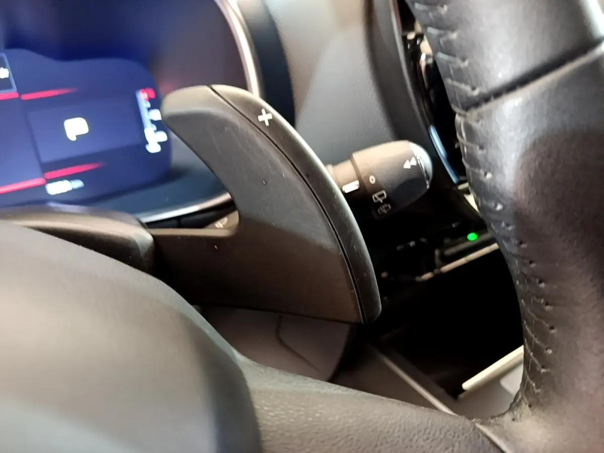 Gros plan sur la palette de changement de vitesse droite noire du volant cuir du Citroën C5 Aircross 2023, intérieur moderne.