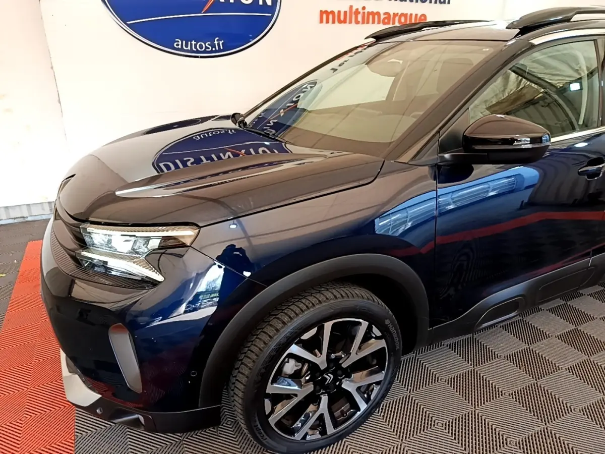 Vue 3/4 avant droit d'une Citroën C5 Aircross 2023 bleu foncé avec jantes alliage et phares LED distinctifs.