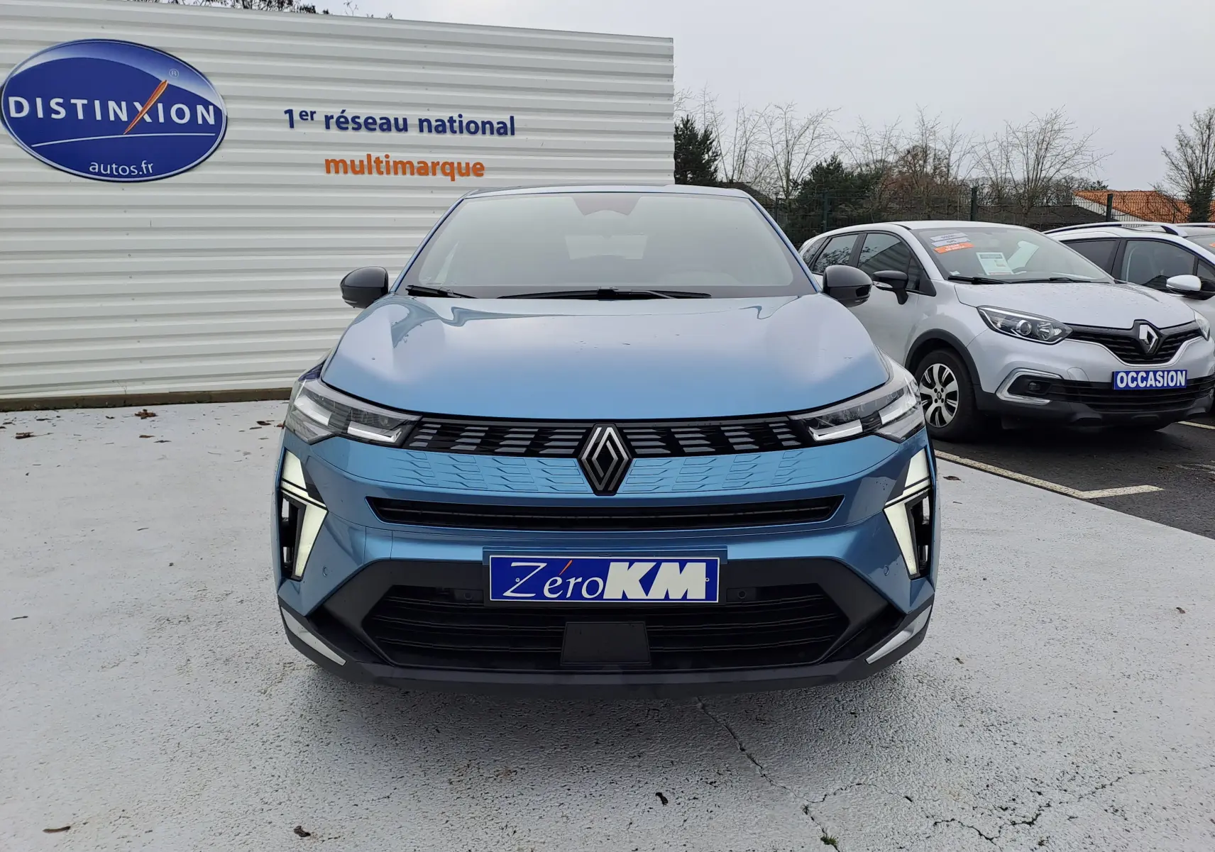 Vue avant d'une Renault Symbioz bleu mercure 2025 avec signature lumineuse verticale et calandre moderne.