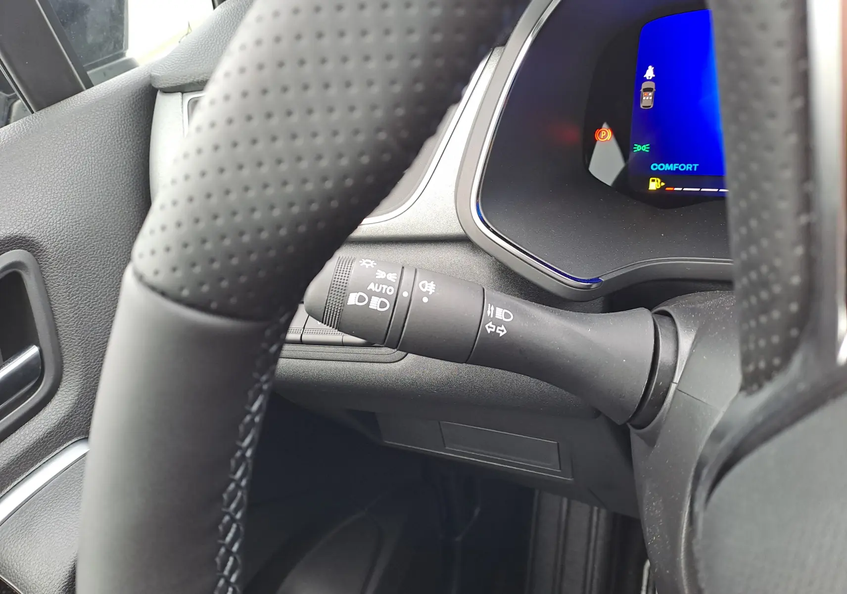 Gros plan sur la manette de clignotants et partie du tableau de bord numérique bleu de la Renault Symbioz 2025.