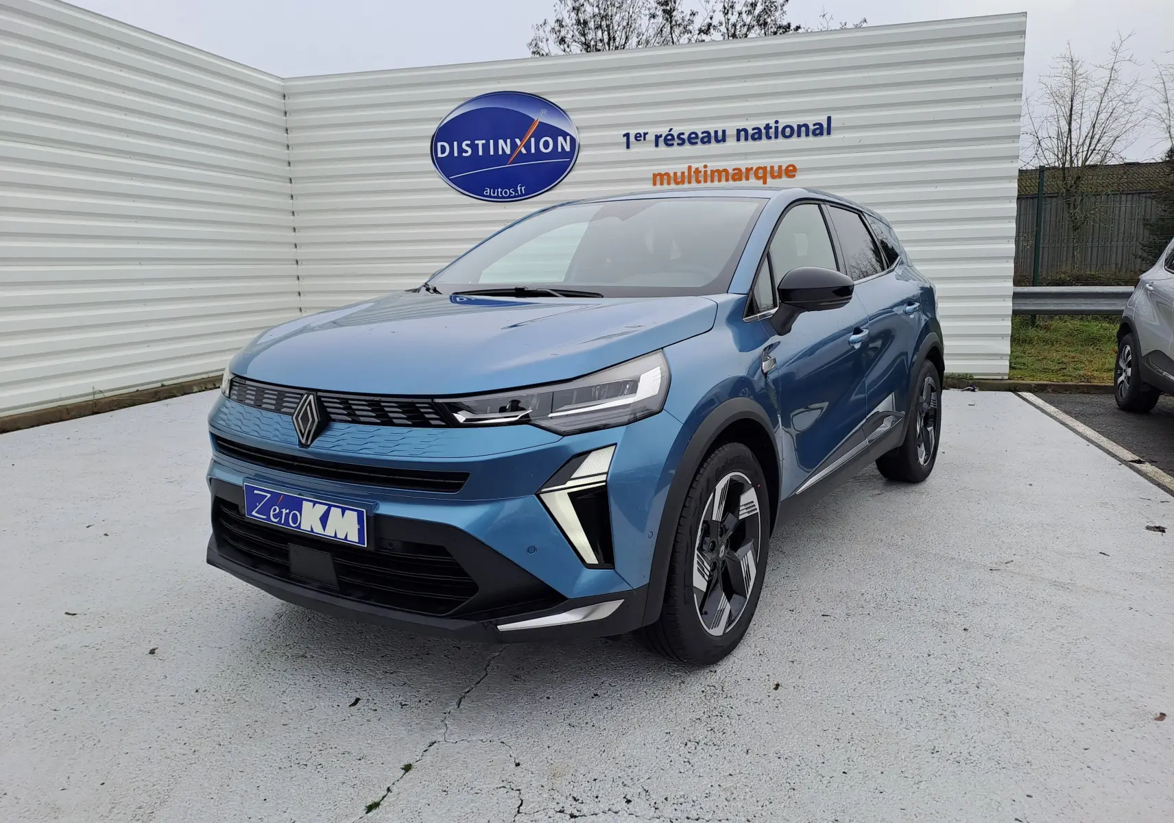 Vue 3/4 avant droite d'une Renault SYMBIOZ bleu mercure avec calandre moderne et jantes bi-ton distinctives.