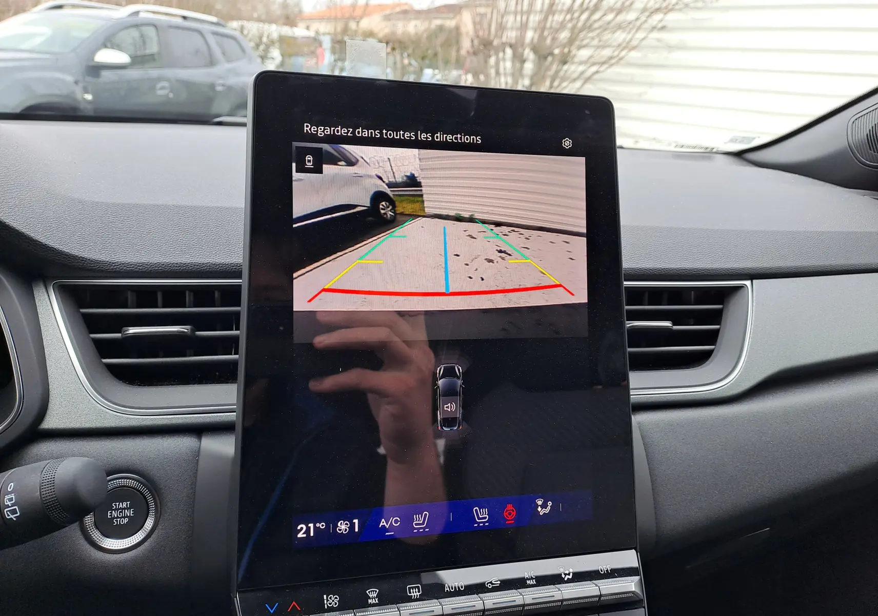 Vue intérieure du tableau de bord de la Renault Symbioz 2025 avec écran tactile affichant la caméra de recul et les commandes climatiques.