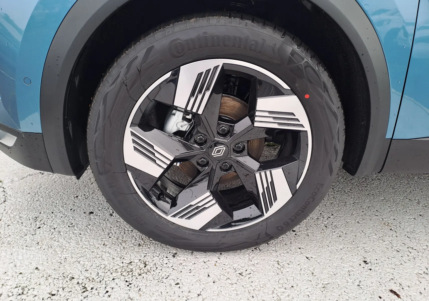 Gros plan sur la roue avant droite bleu mercure d'une Renault Symbioz 2025 avec jante noire et argentée au design géométrique.