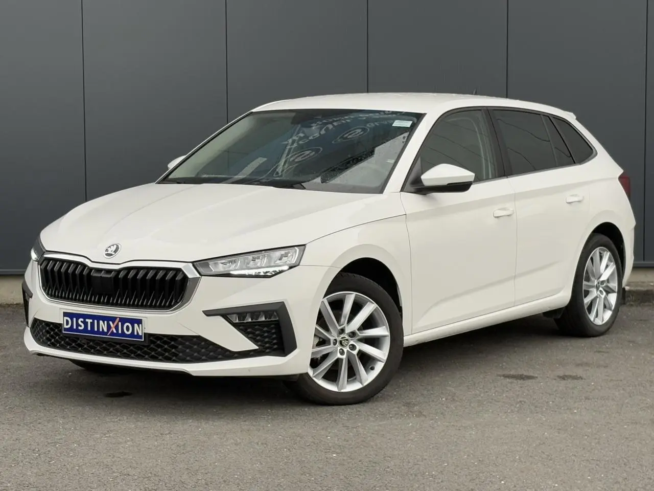 Vue 3/4 avant d'une Skoda Scala blanche Candy avec jantes alliage 17 pouces et calandre noire distinctive.