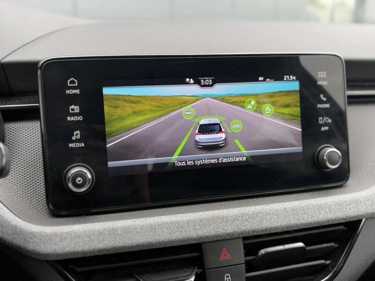 Écran tactile central affichant l'aide à la conduite du Skoda Scala blanc Candy, vue intérieure du tableau de bord.