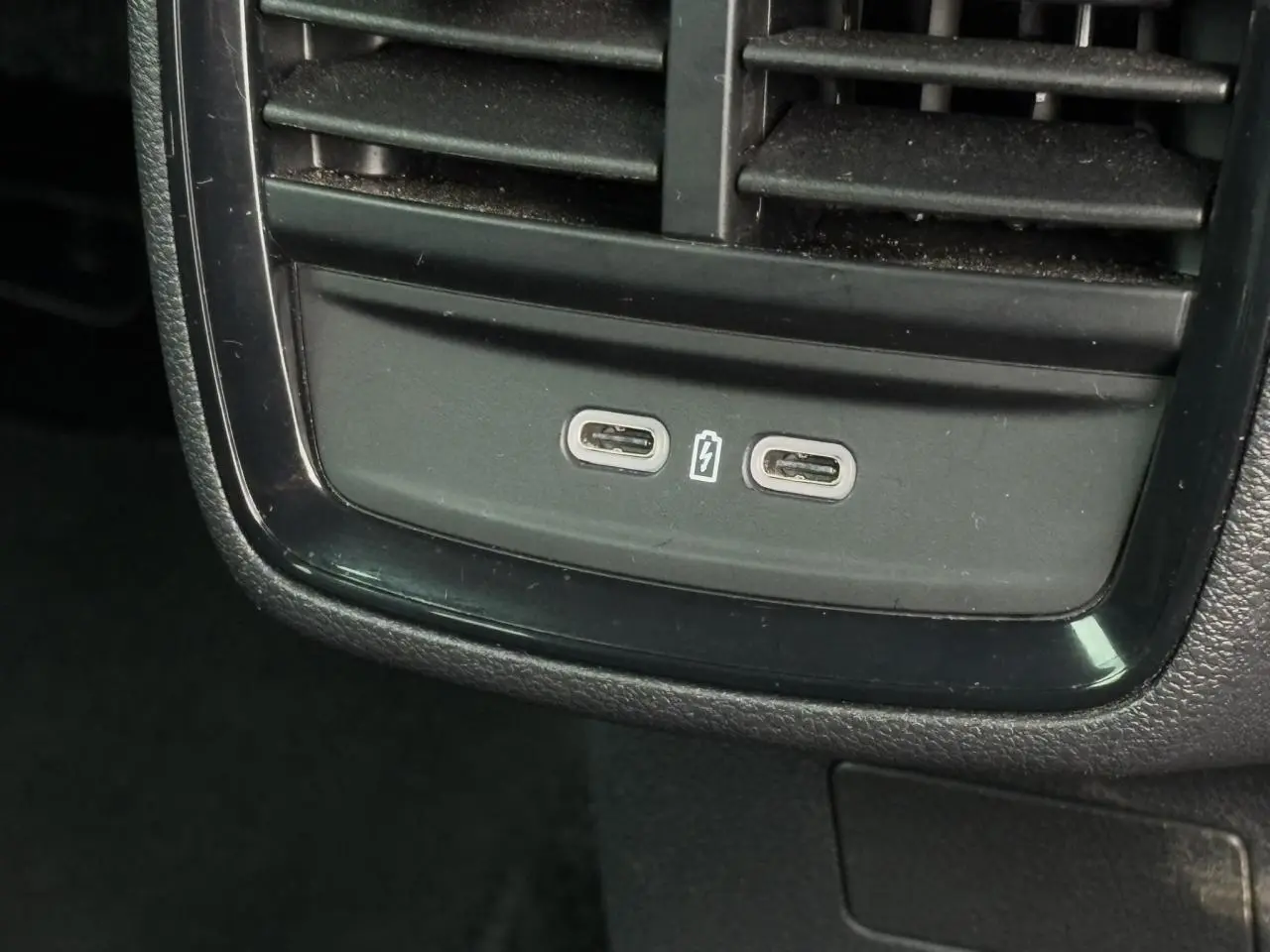 Vue rapprochée des ports USB-C de recharge situés sous les aérateurs arrière d'un Skoda Scala blanc Candy 2024.