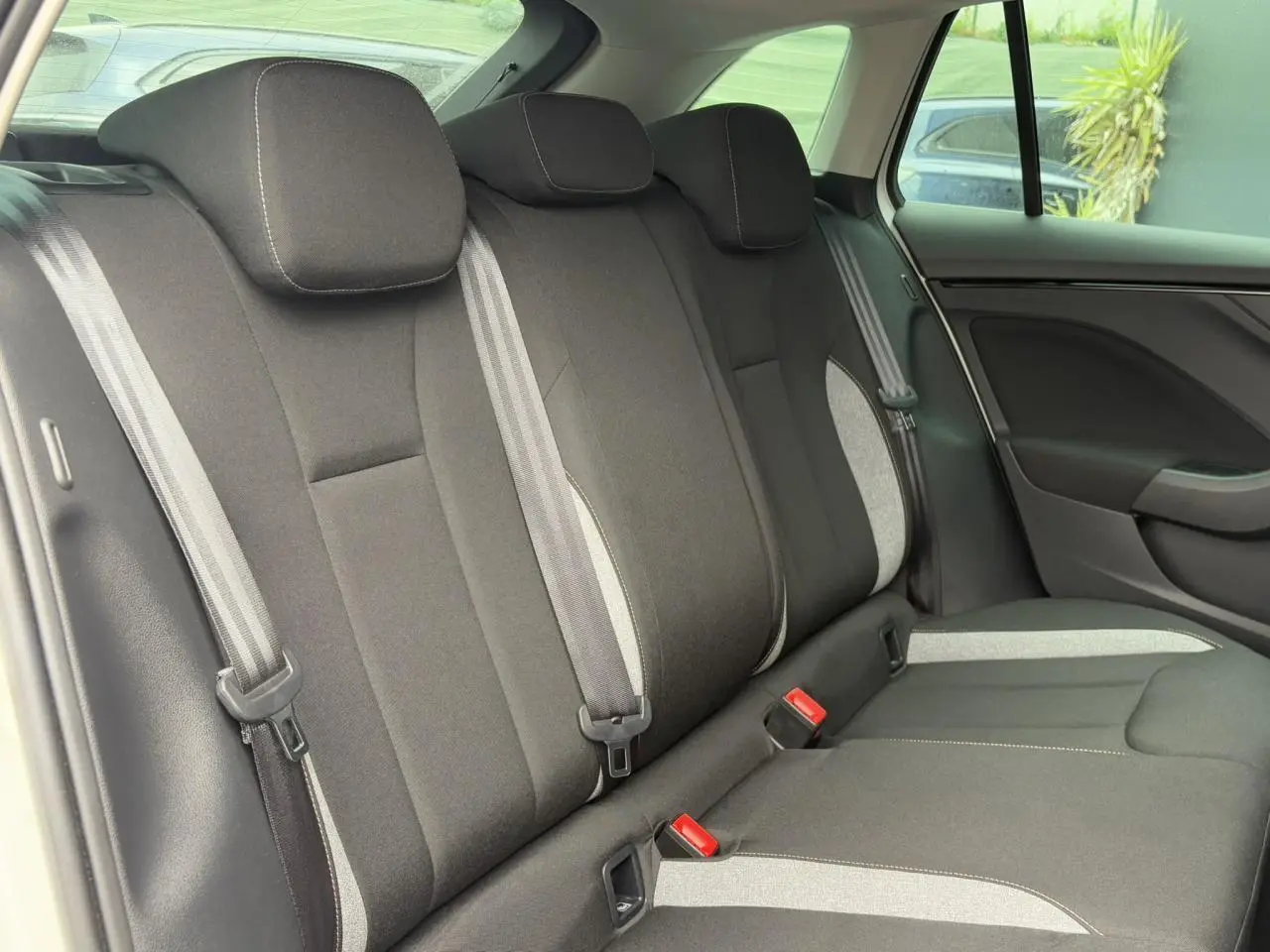 Vue intérieure arrière des sièges noirs et gris du Skoda Scala 2024, montrant les appuie-têtes et ceintures de sécurité.