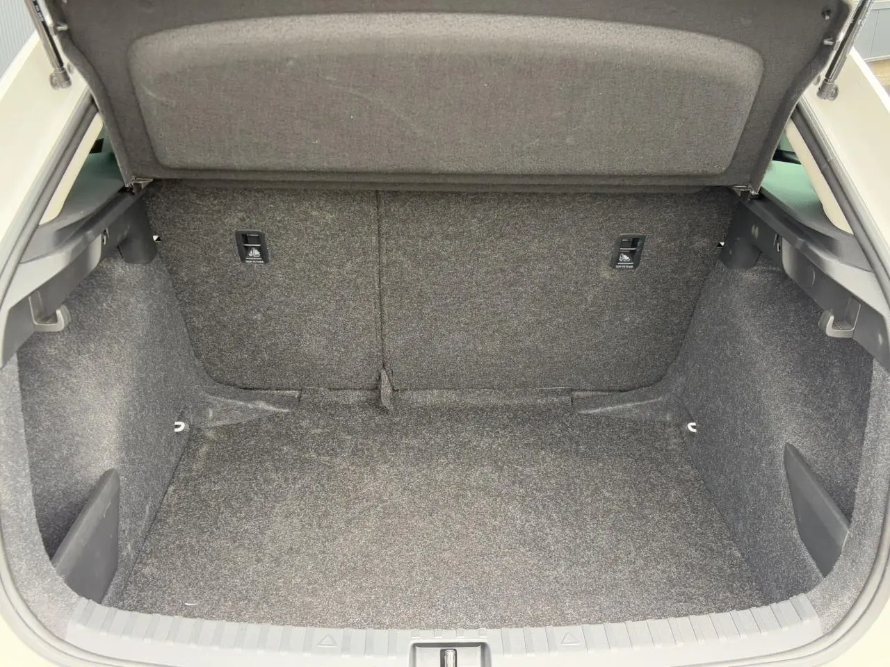 Coffre ouvert de la Skoda Scala blanc Candy 2024, montrant un espace de chargement propre et bien fini.